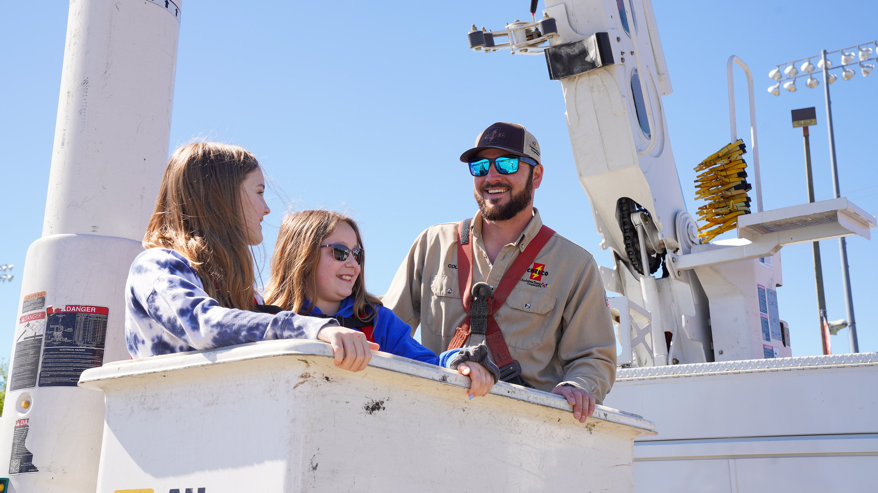 CHELCO Line Technician Cole Hatcher takes children on bucket truck rides
